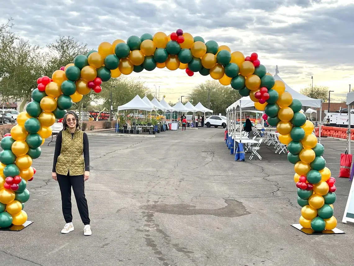 A girl standing near a balloon gate at a place